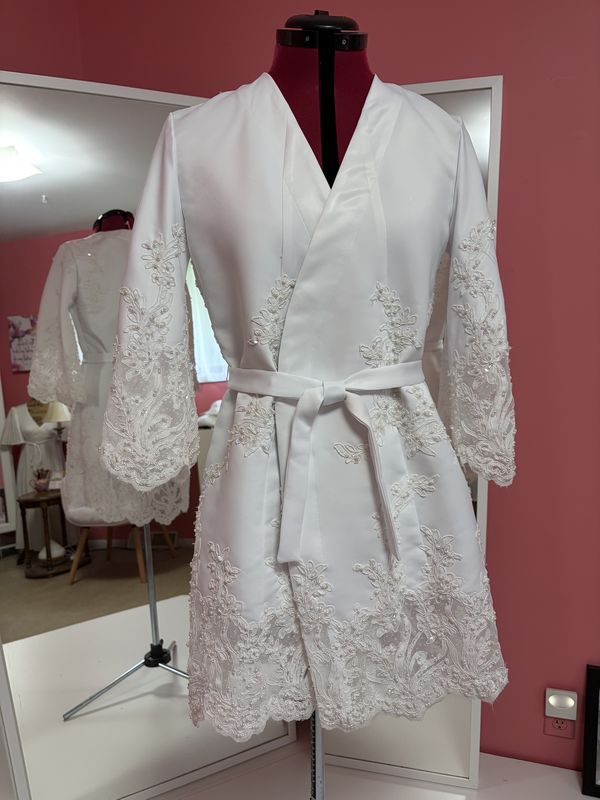 After: a short white robe with lace-trimmed sleeves and hem and a tie belt, on a dress form