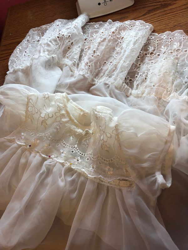 Close-up of white heirloom christening gowns with lace and pintucks