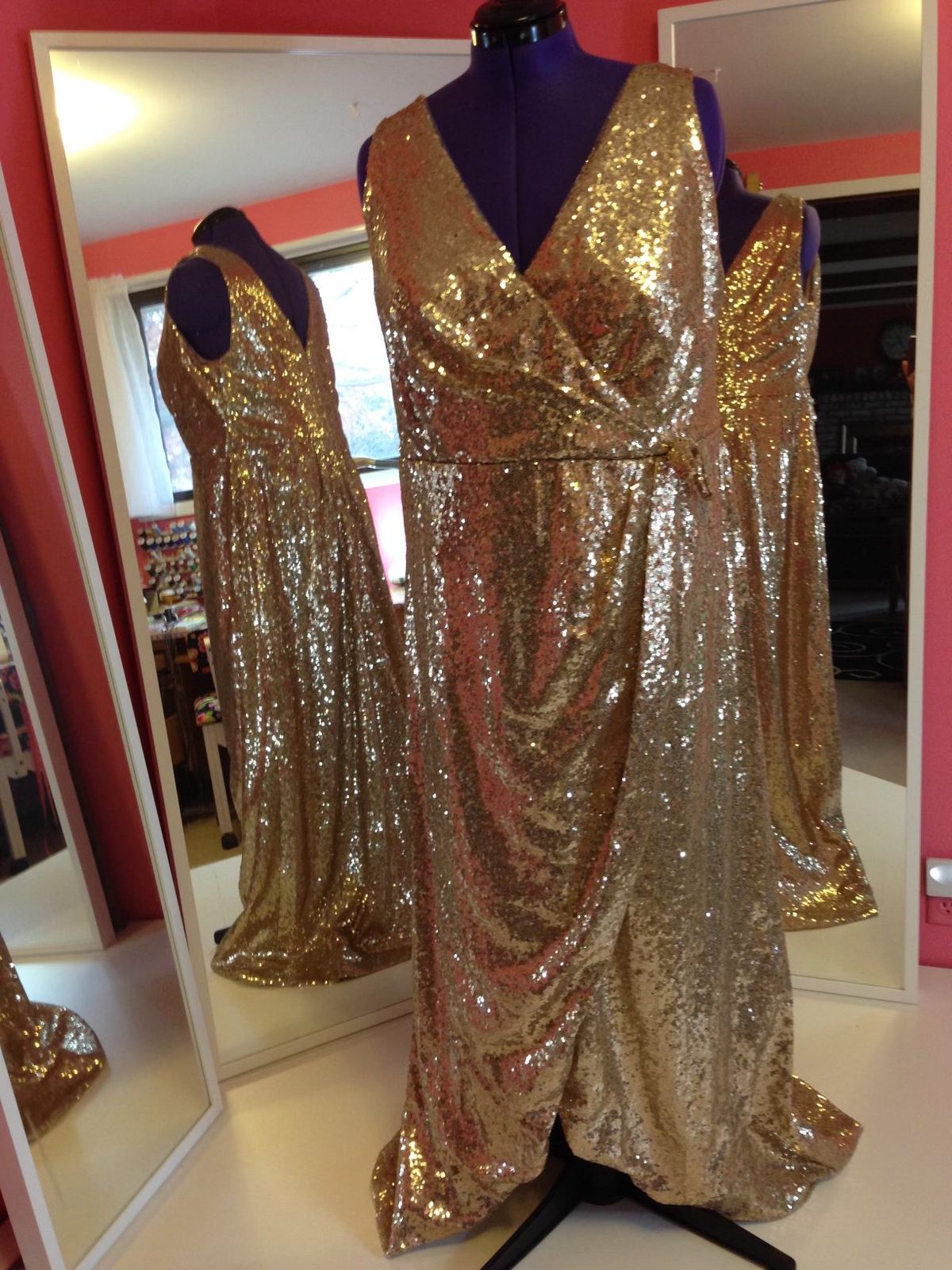 A gold sequin wrap gown on a dress form in Wendy’s fitting room