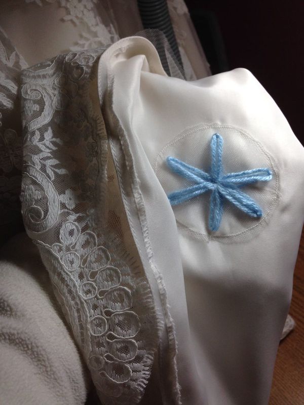 A blue embroidered star stitched inside a lace garment
